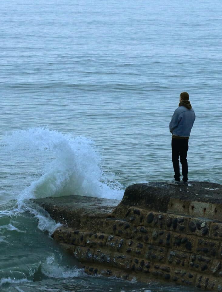 man pondering a recent loss of a loved one at the ocean in Southern California